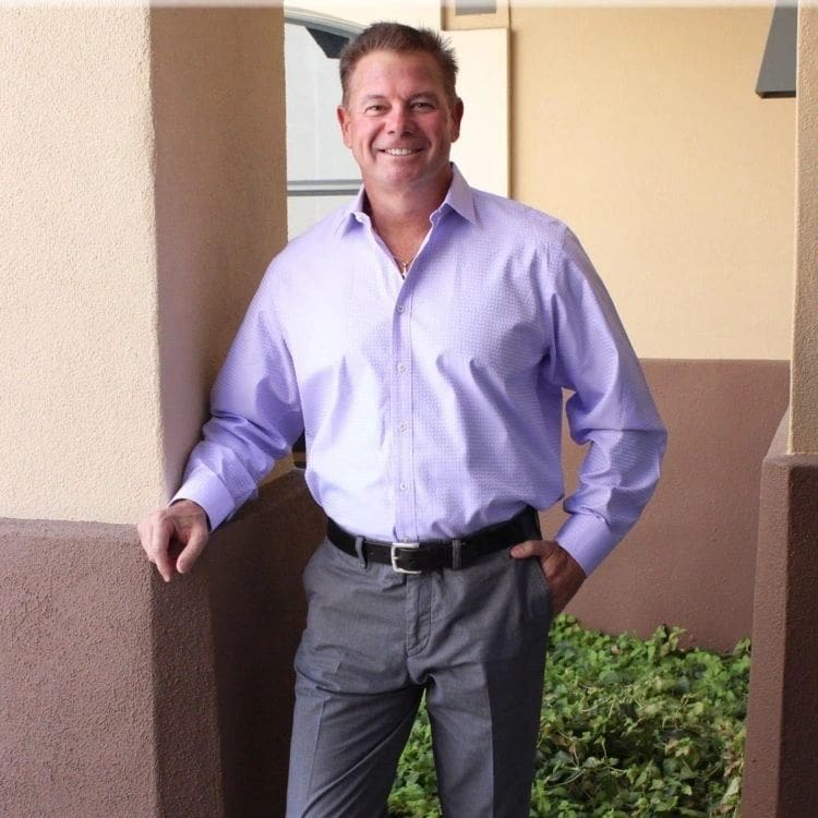 A man standing in front of some bushes